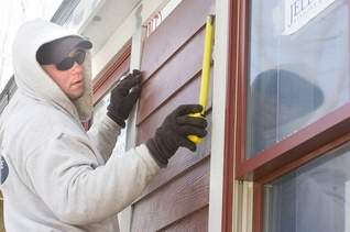 Vadim Pavlovski hangs HardiPlank siding that is both durable and fire-resistant. (Bill Bresler | staff photographer)